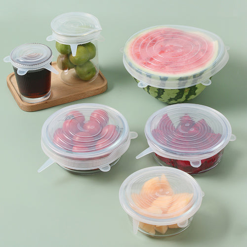 Set of silicone food covers on various fruits and containers on a light green background